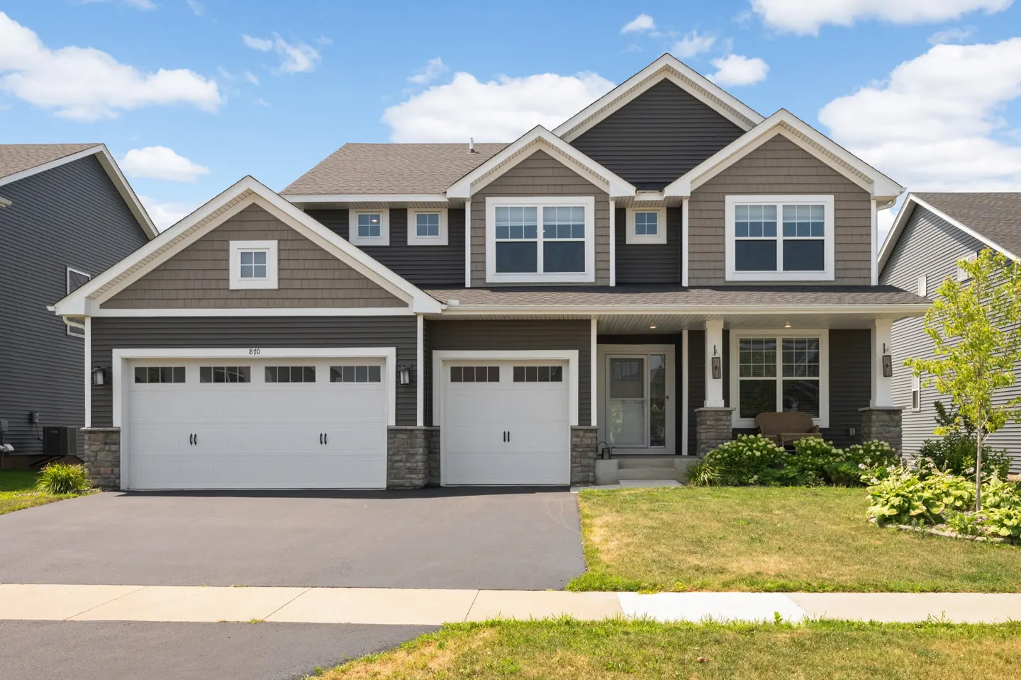 Front exterior of 870 Spancil Hill Dr in Woodbury, MN with three car garage and covered front porch